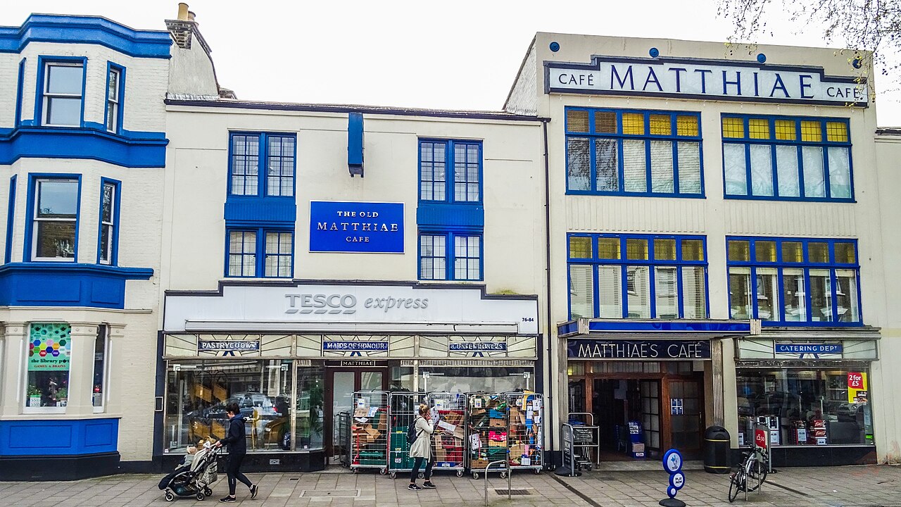 Former baker's shop and bakery, with cafe, function room and accommodation on upper floors. Five late C19 terraced houses heavily remodelled in the late 1930s, which is where the special interest lies