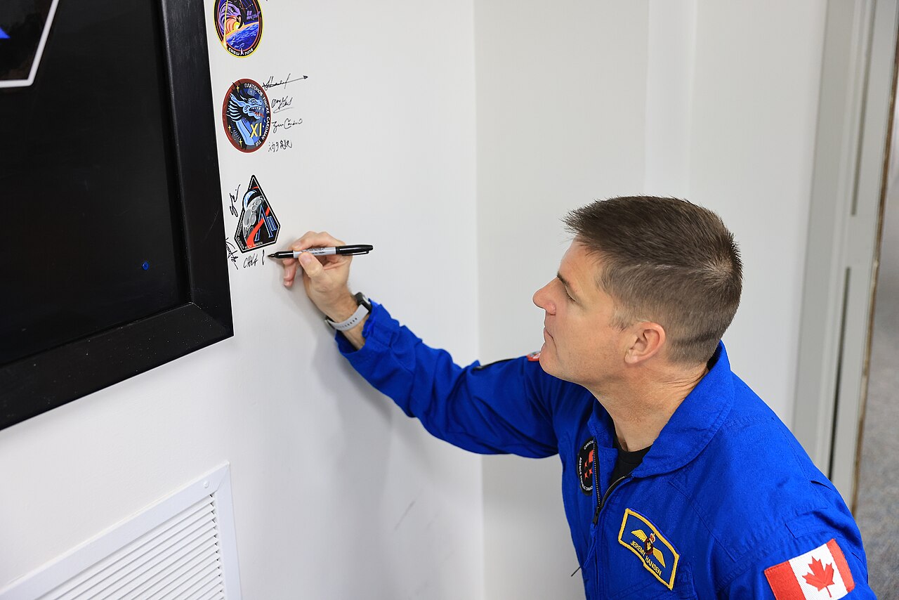 Artemis II crew at walkout, signing the traditional patch on the wall at Kennedy Space Center, March 30, 2026