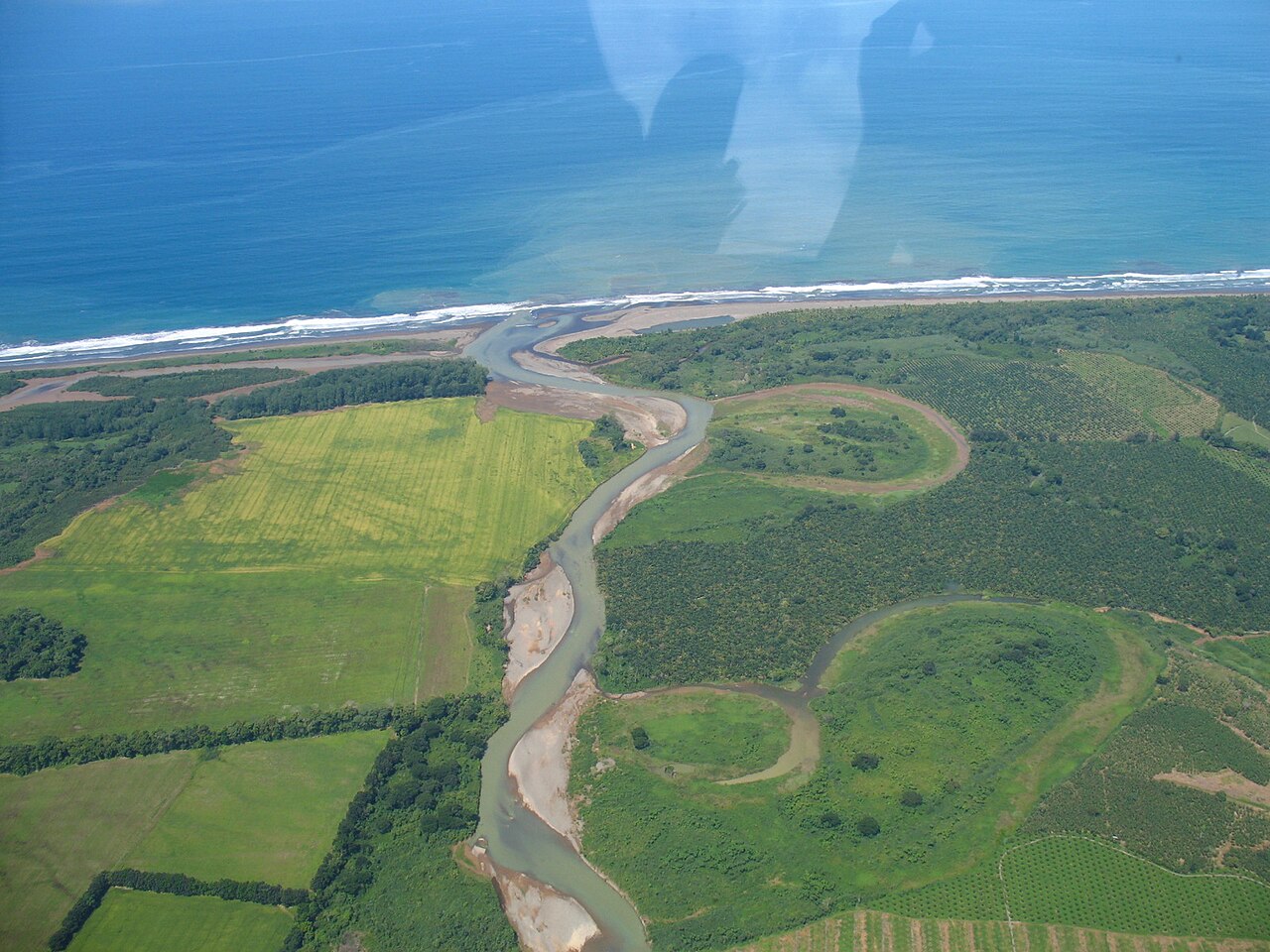 A meandering river with active water-filled meanders and old abandoned sediment-filled meanders in Puntarenas Province in Costa Rica.