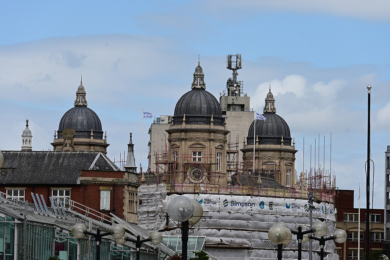 The modern cityscape of Kingston upon Hull in July 2023. From left to right are the roofs of the Princes Quay shopping centre, Hull City Hall, the Hull Maritime Museum and in the background, Kingston 