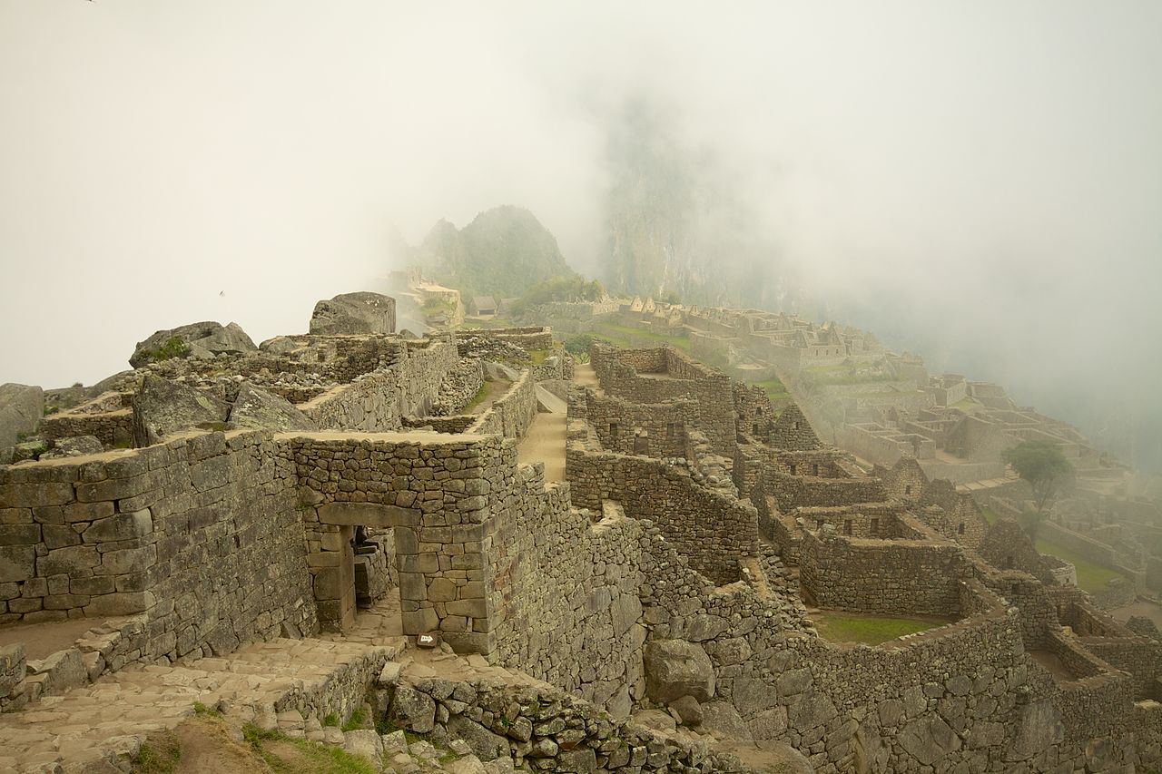 As the fog lifts over the ruins Huayna Picchu starts to appear.