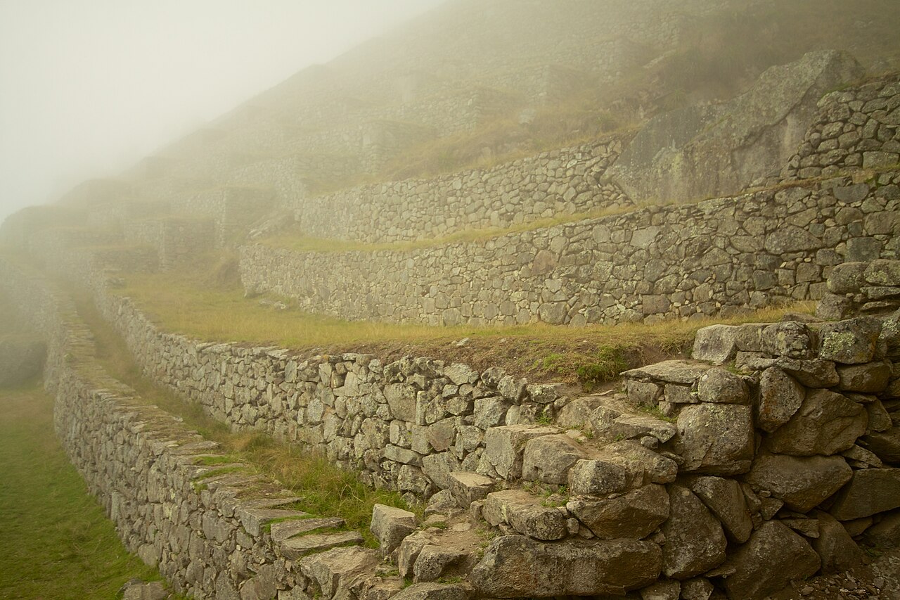 The ruins and terraces of Machu Picchu look amazingly mysterious and even more ancient shrouded in the pre-dawn fog, imagining that anything could be discovered just beyond your sight.