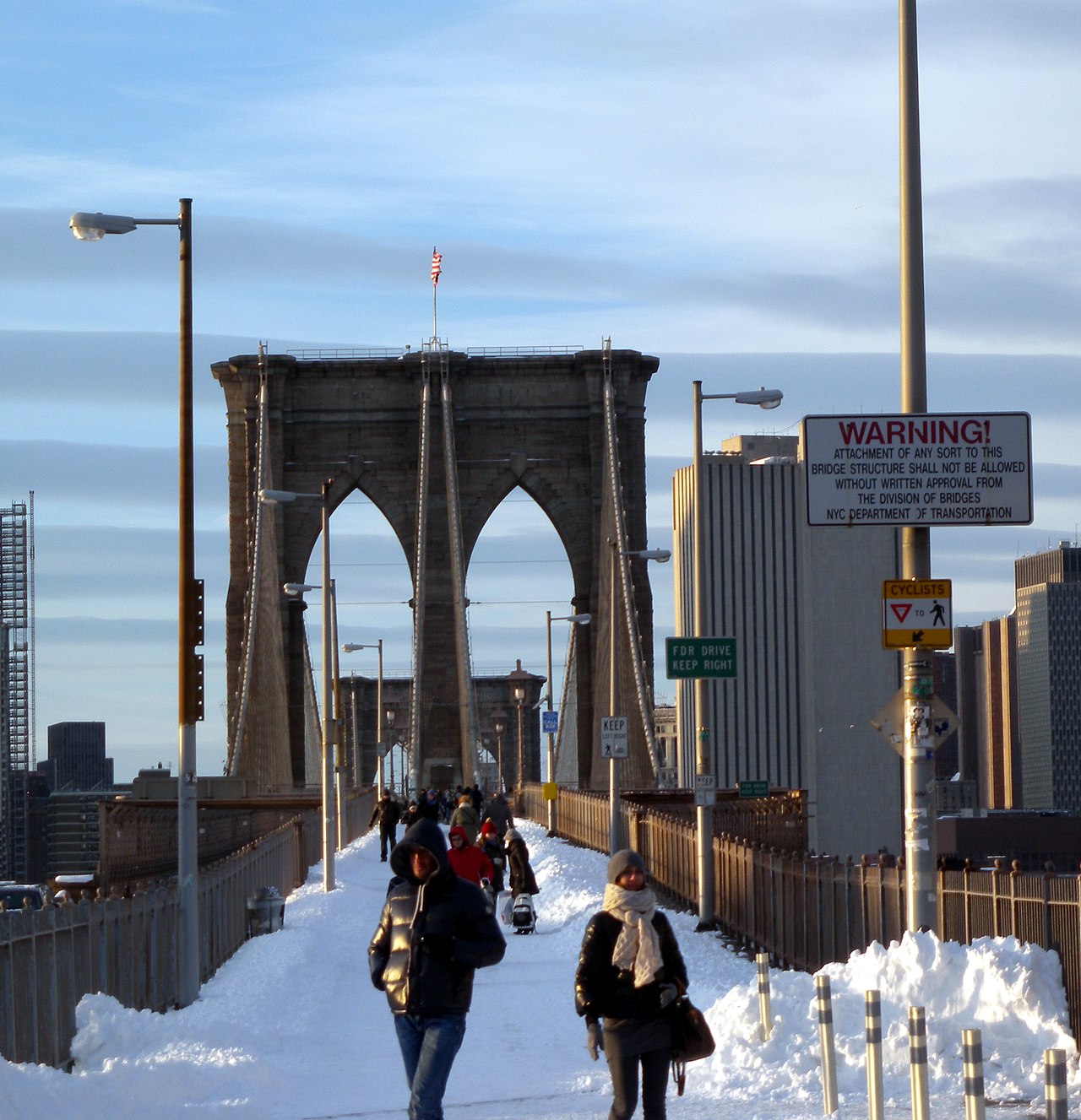 Looking northwest along Brooklyn Bridge central walkway from near the Washington Street stair on a mostly sunny afternoon after snow.