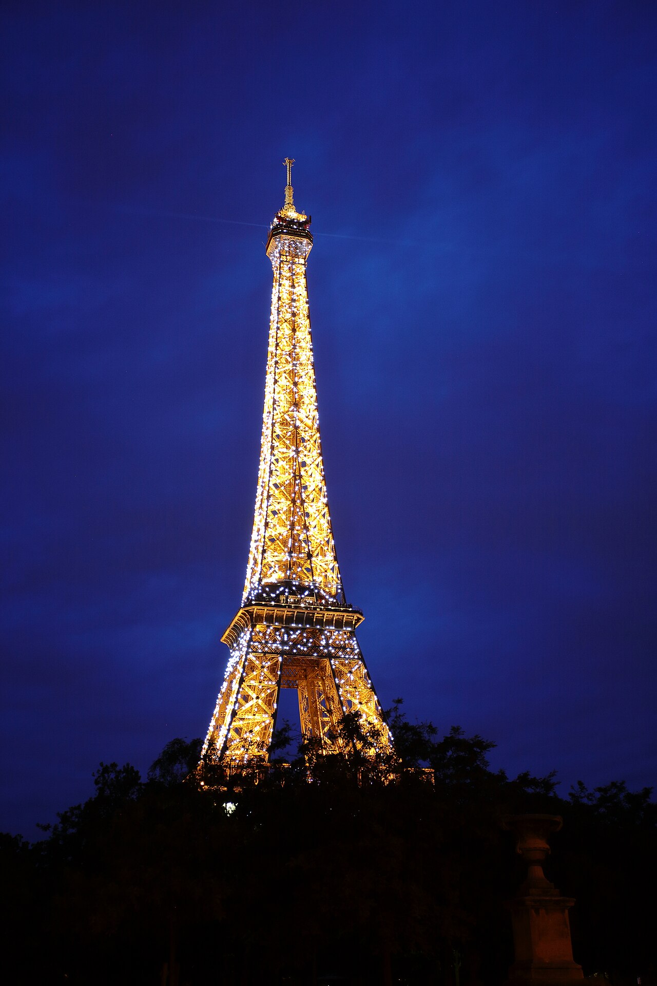 The iconic landmark, illuminated against the deep night sky, embodies the romance and timeless charm of Paris. As the lights twinkle, they reflect the city's enduring allure, making this moment a capt