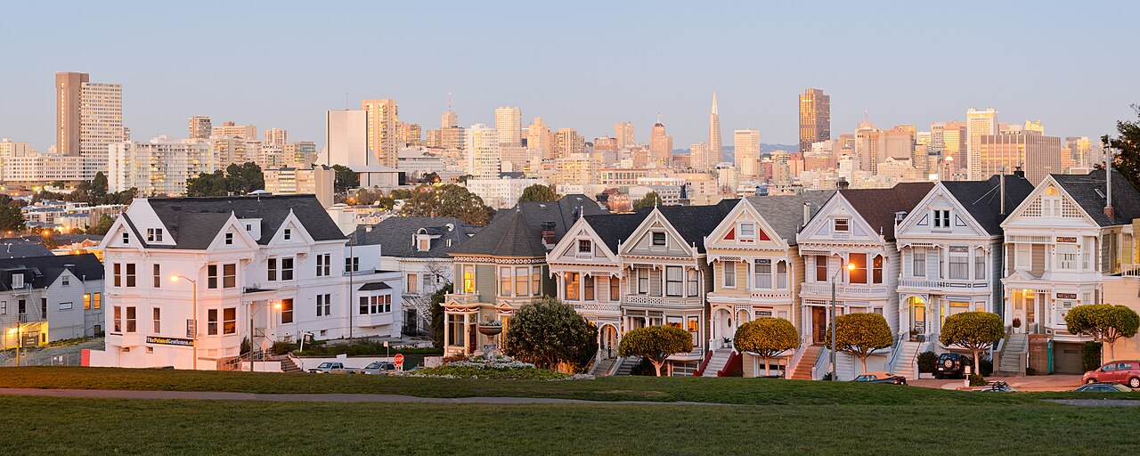 A two-segment panorama of the Painted Ladies in the city of San Francisco with the skyline of the city in the background.