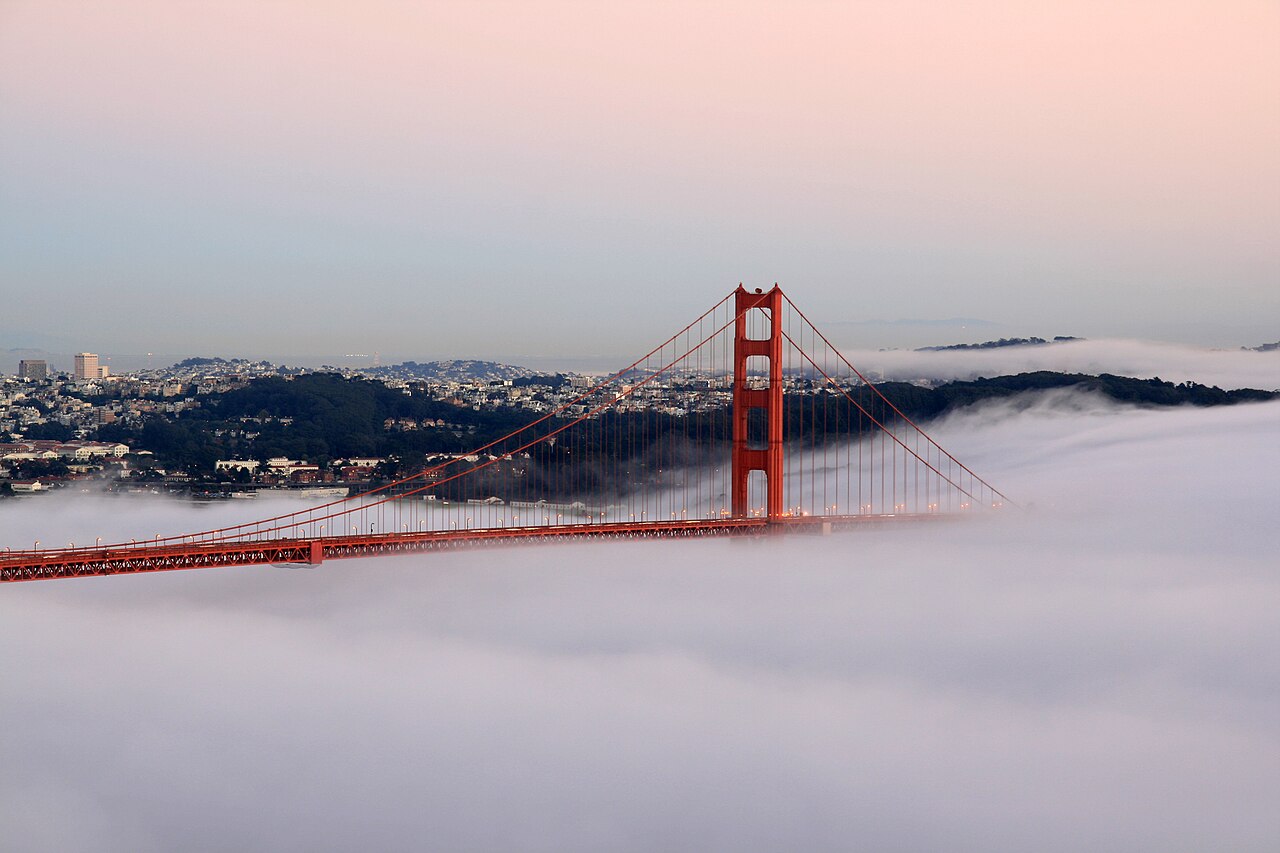 Golden Gate Bridge (San Francisco, CA, USA) at sunset and coverd by fog.