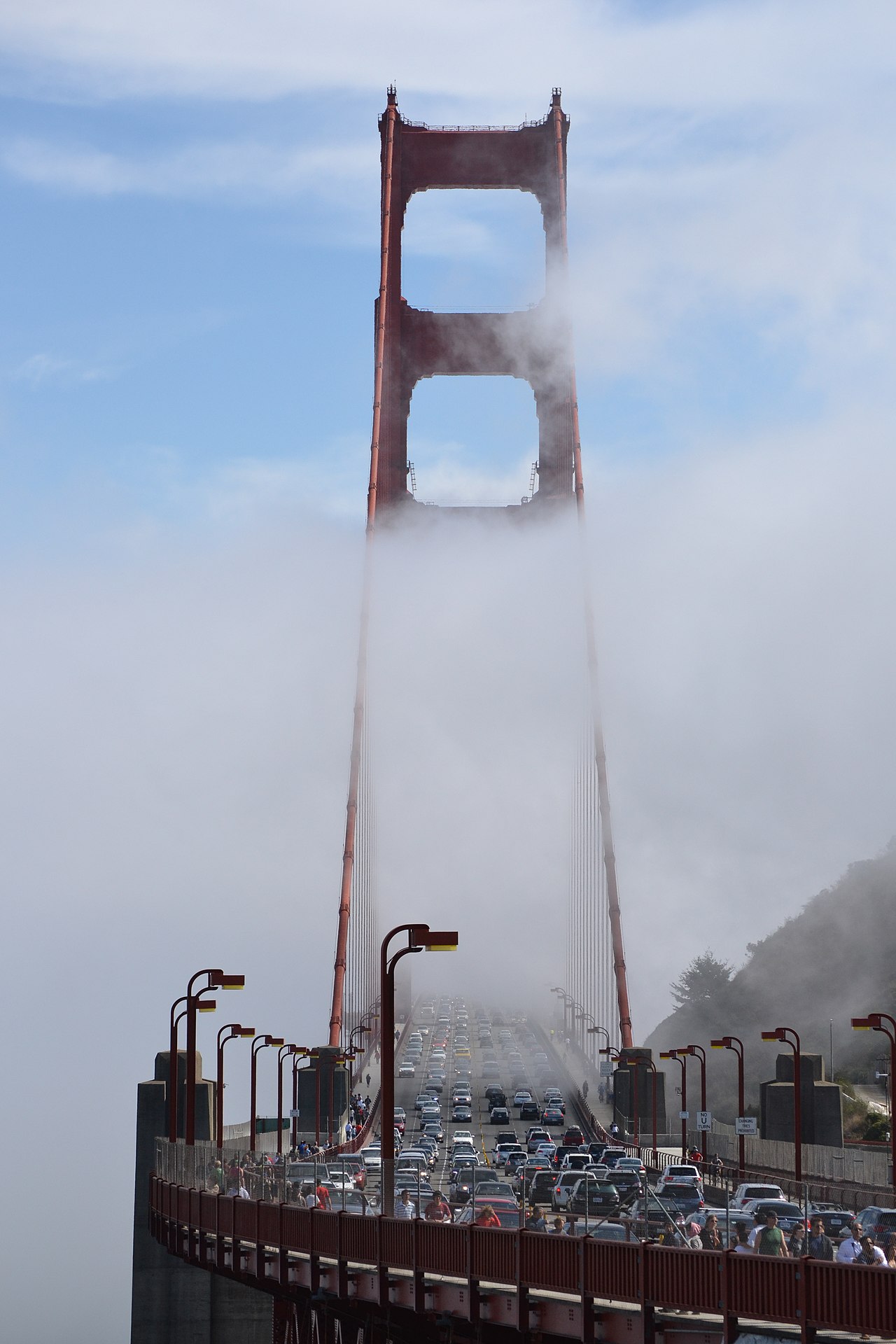 The golden gate Bridge with fog, cars and pedestrians as seen from Vista Point, San Fransisco, US.