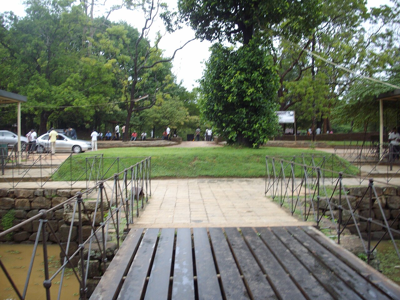 The moat and outer entrance to Sigiriya fortress gardens, with water reflecting the surrounding walls and vegetation.