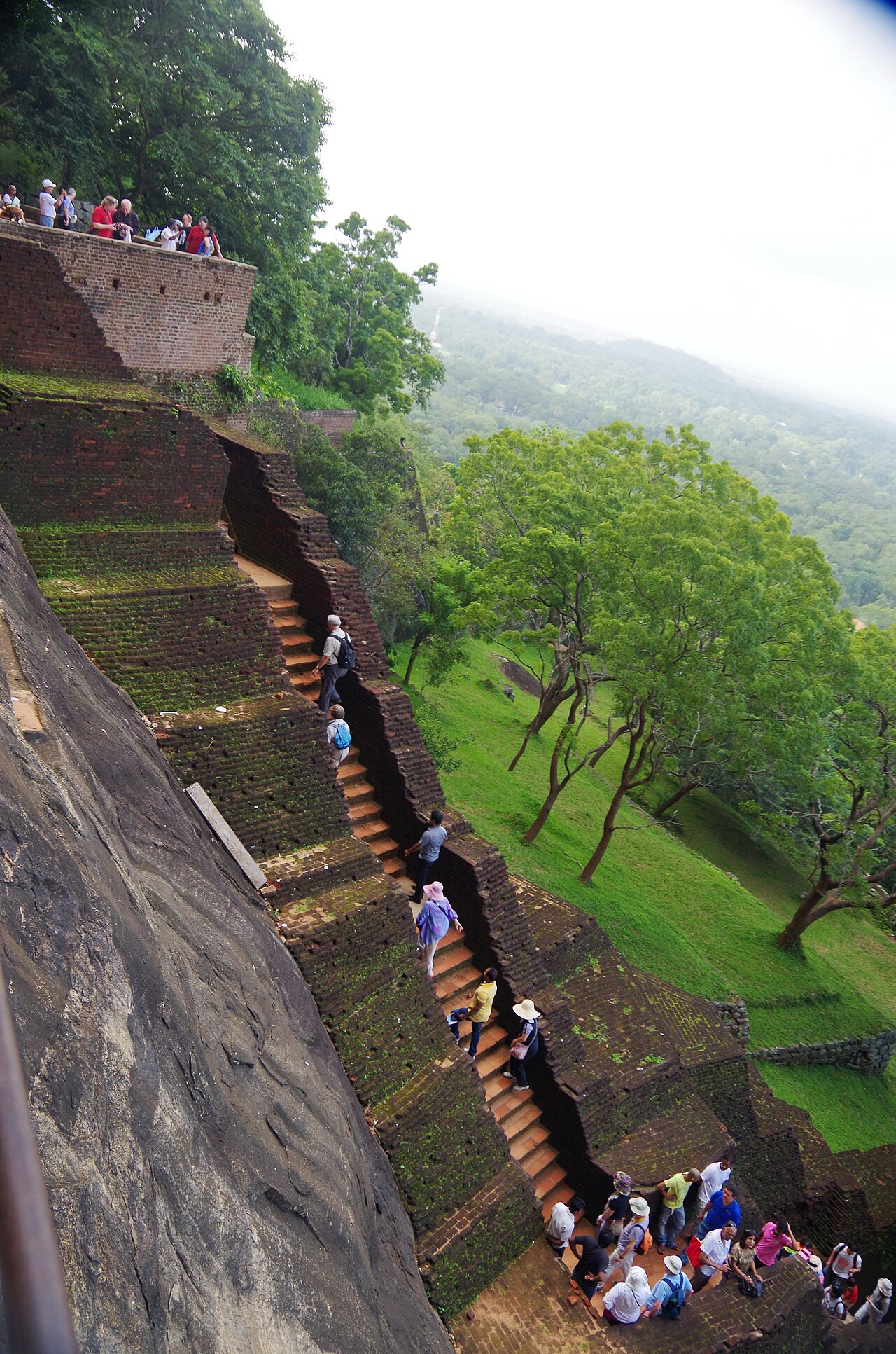 Steep metal staircase along the cliff face of Sigiriya leading up toward the Mirror Wall and frescoes gallery.