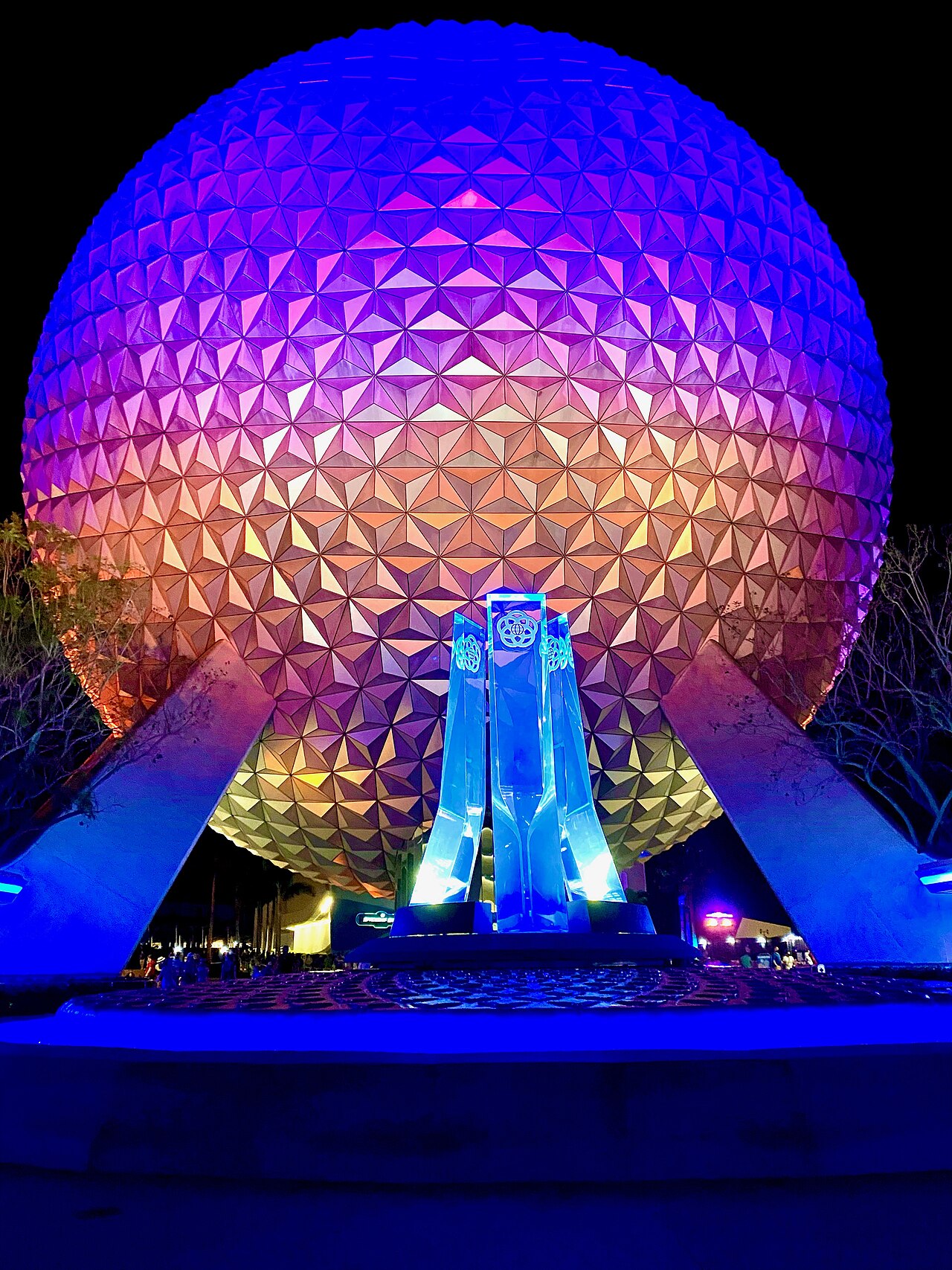 Photo of the iconic geodesic sphere at EPCOT, with the new entrance fountain, at night