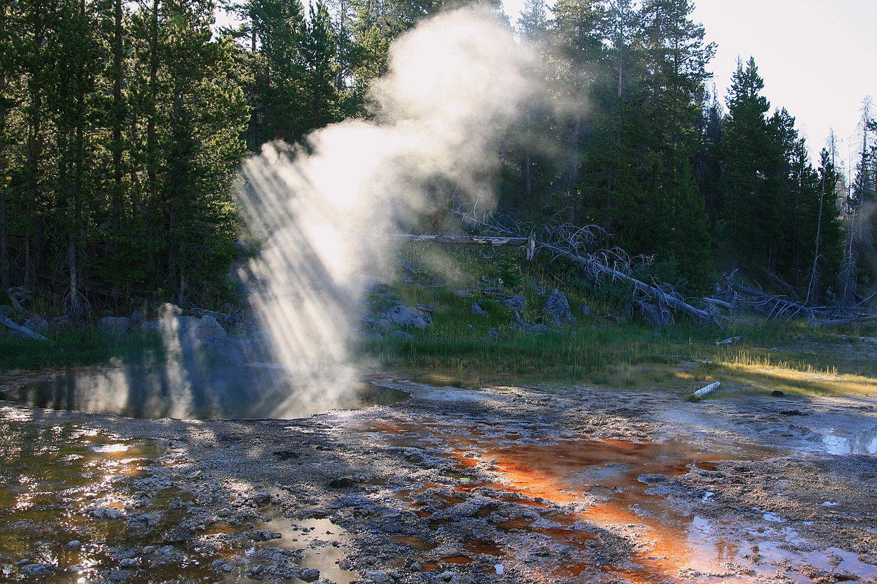 crepuscular rays over the steam from a hot spring in Yellowstone National Park